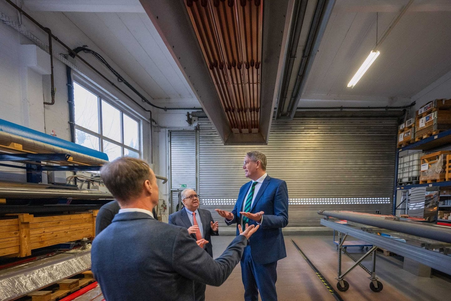 Personen diskutieren in einer Werkstatt.