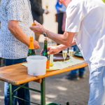People serving drinks at an outdoor event.