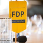 Yellow FDP banner on a table.
