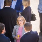 People chat at an outdoor reception.