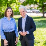 Two women smile in the sunny park.