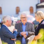 Three people in conversation outdoors.