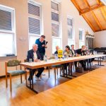 People at the conference table with FDP sign in the hall.