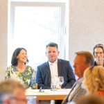People sitting at a table at an event.