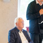 Two men having a conversation in a room.