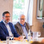 People at a meeting with glasses on the table.