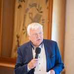Elderly man gives speech with microphone