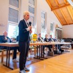 Person speaks at an event with an audience.